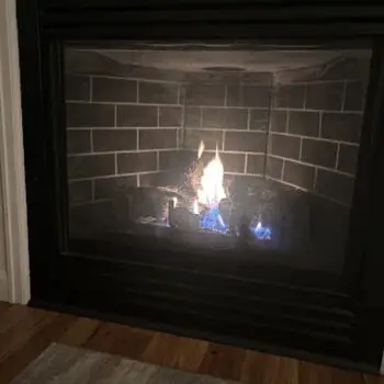 Lit fireplace with brick interior