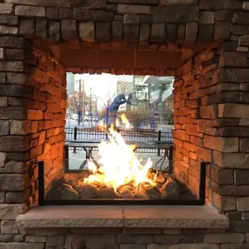 Outdoor stone fireplace with flames
