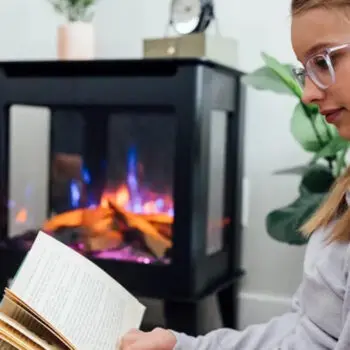 Person reading by cozy fireplace